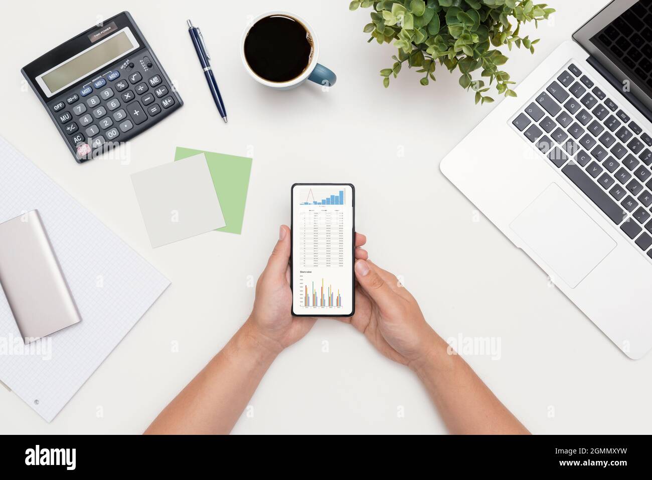Analyst arbeitet mit den Daten. Grafiken auf dem Smartphone-Bildschirm, flache Lay-Komposition Stockfoto