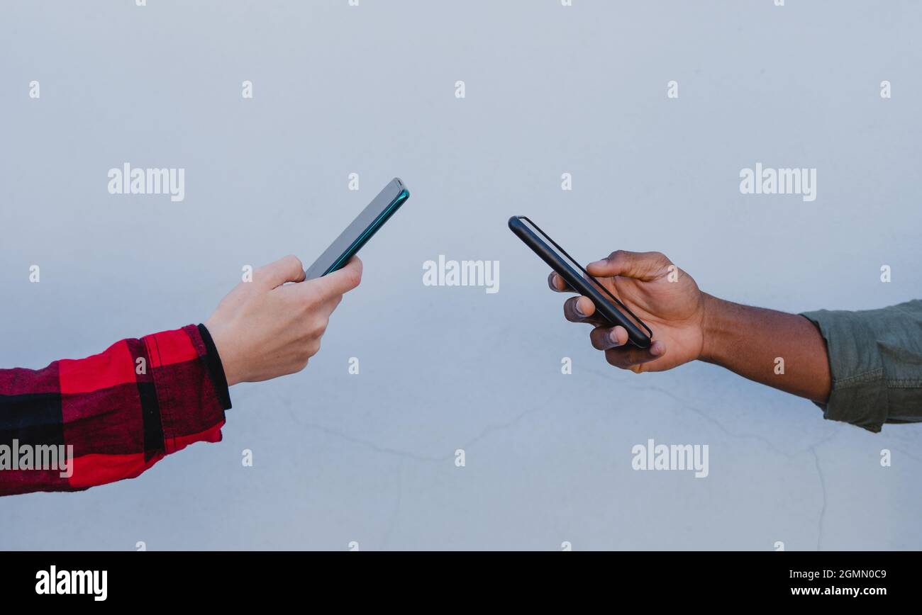 Nahaufnahme von jungen gemischten Paar Hände mit Smartphones auf weißem Hintergrund Stockfoto
