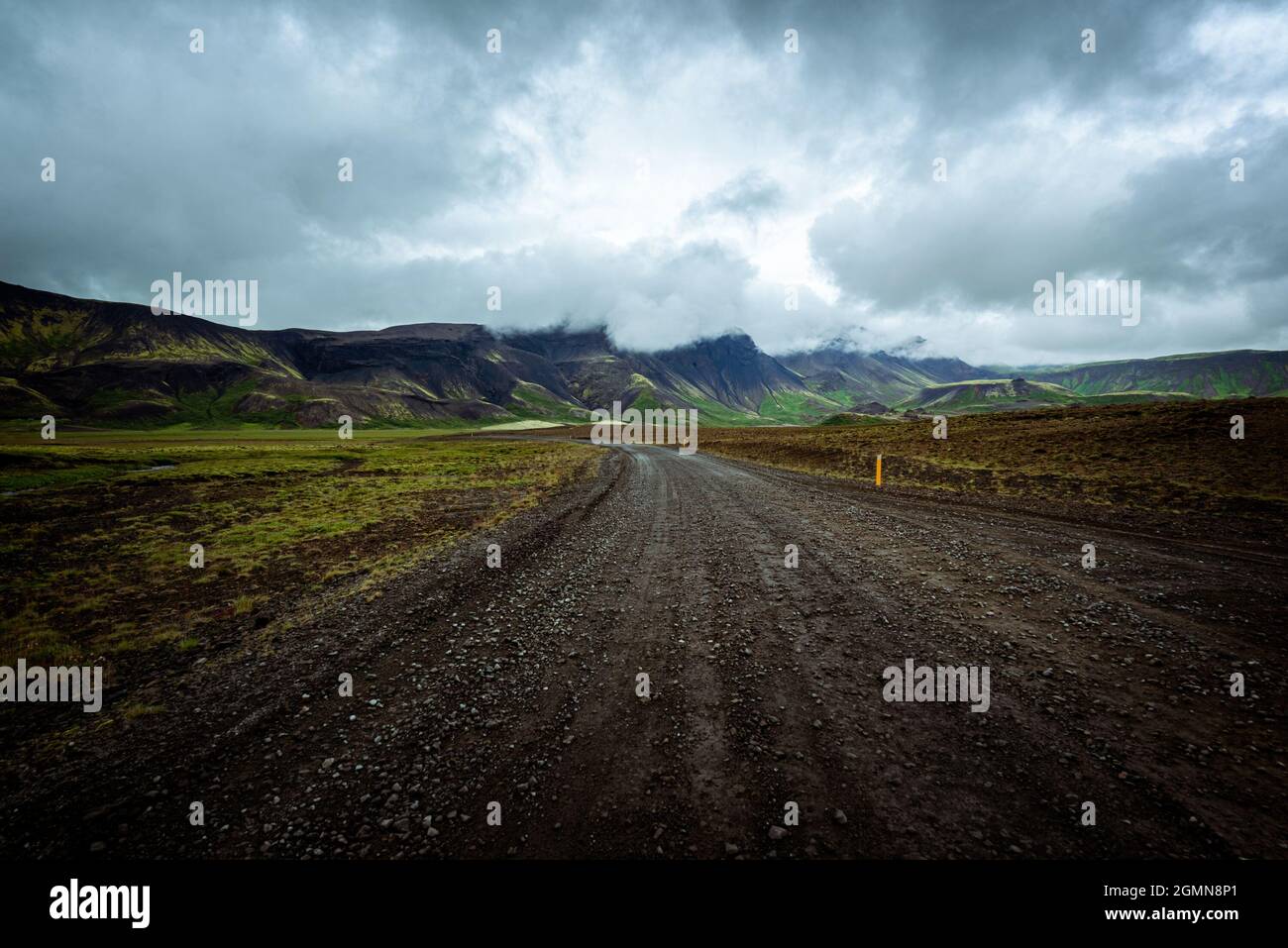 Fahren auf einer unbefestigten Straße im Sommer in Island, Berglandschaft, launischer Himmel mit dunklen Wolken Stockfoto