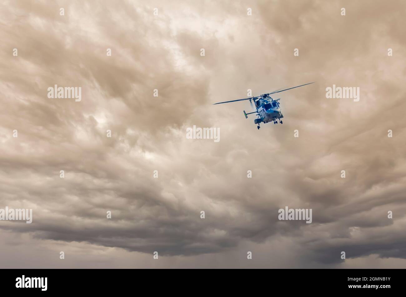 Der von Hindustan Aeronautics Limited entwickelte fortschrittliche leichte Hubschrauber Dhruv fliegt vor dem Hintergrund grauer, stürmischer Monsunwolken. Stockfoto