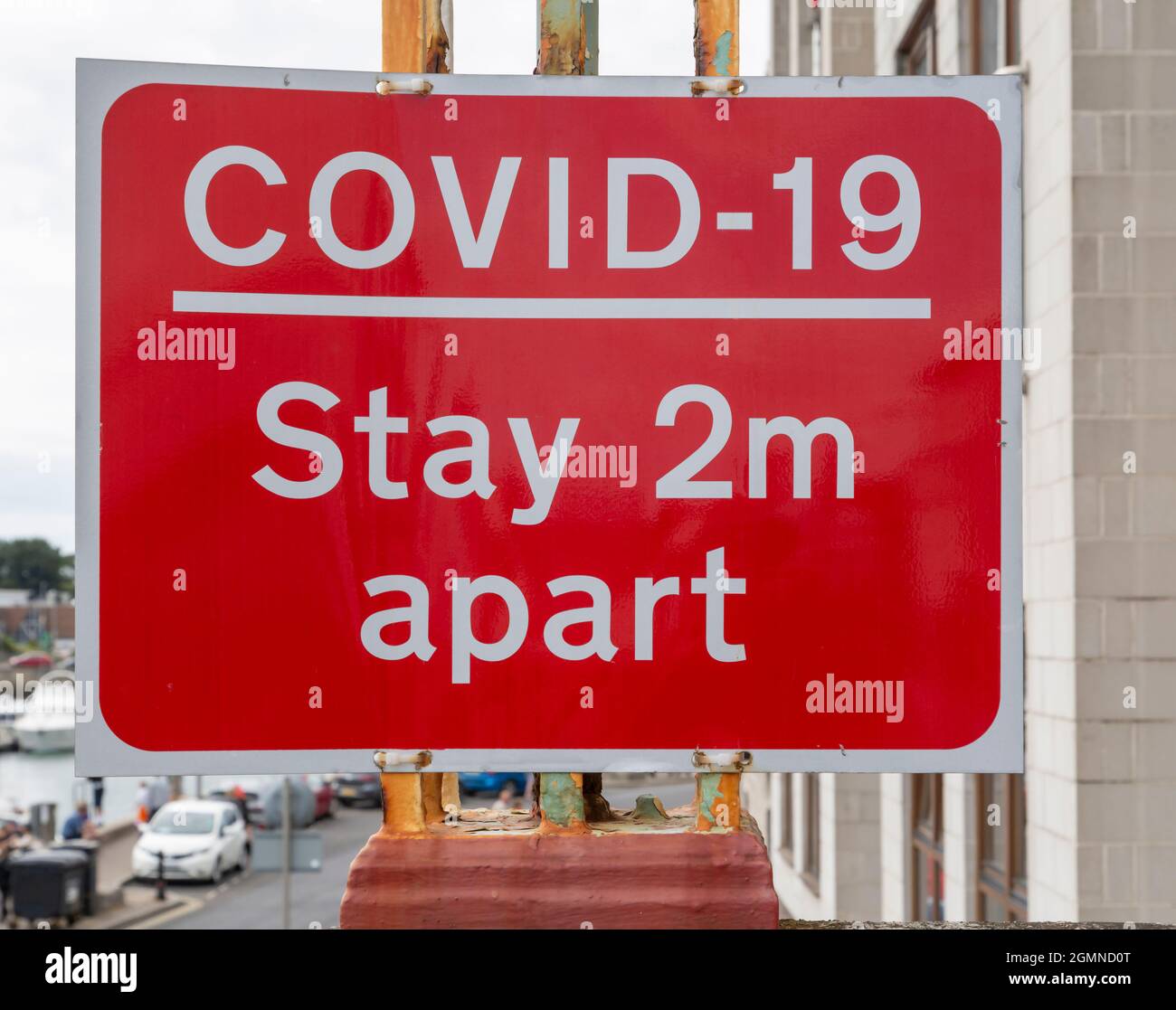 Ein rotes britisches Covid-19-Schild, das die Menschen daran erinnert, zwei Meter voneinander entfernt zu bleiben Stockfoto
