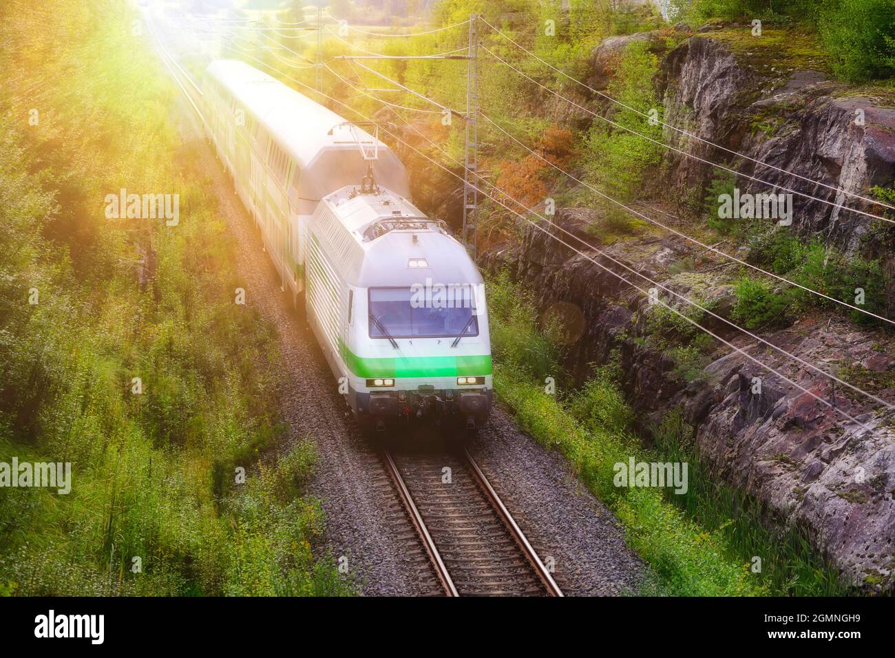 VR Intercity-Zug fährt mit Geschwindigkeit durch ländliche Landschaft mit grünen Bäumen, erhöhte Aussicht. Salo, Finnland. 29. August 2021. Stockfoto