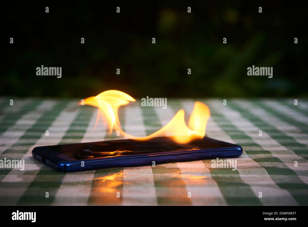 Handy explodiert und brennt. Explosion und Brand von Mobiltelefonen. Gefahr für Smartphones durch Übernutzung oder schlechte Herstellung. Überhitzung wird verbrannt Stockfoto