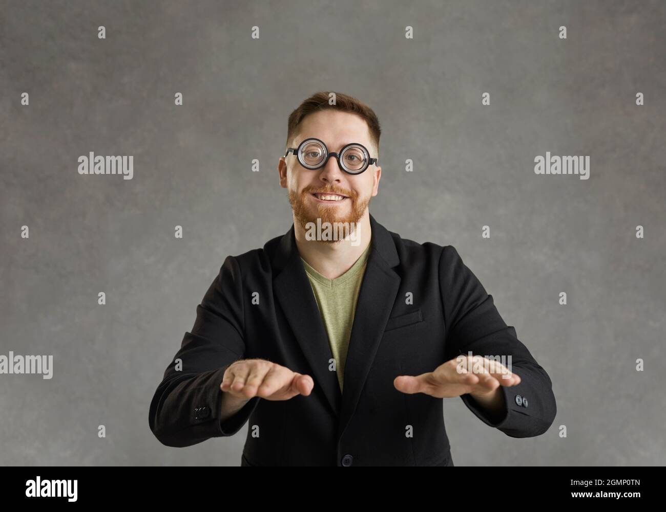 Studioportrait eines lustigen Nerds in runden Brillen, die tanzen und die Kamera betrachten Stockfoto