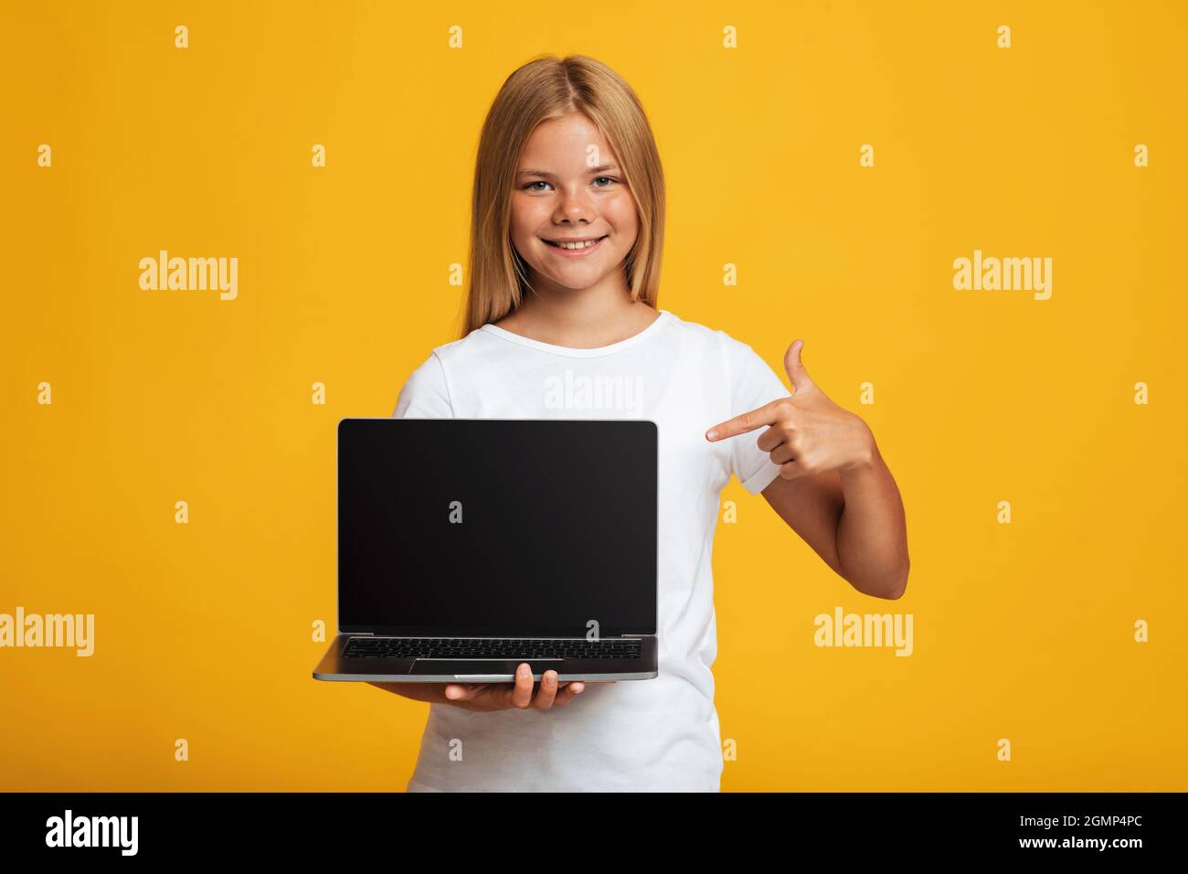 Glücklich teen weiblich zeigen Finger auf Laptop mit leerem Bildschirm Stockfoto