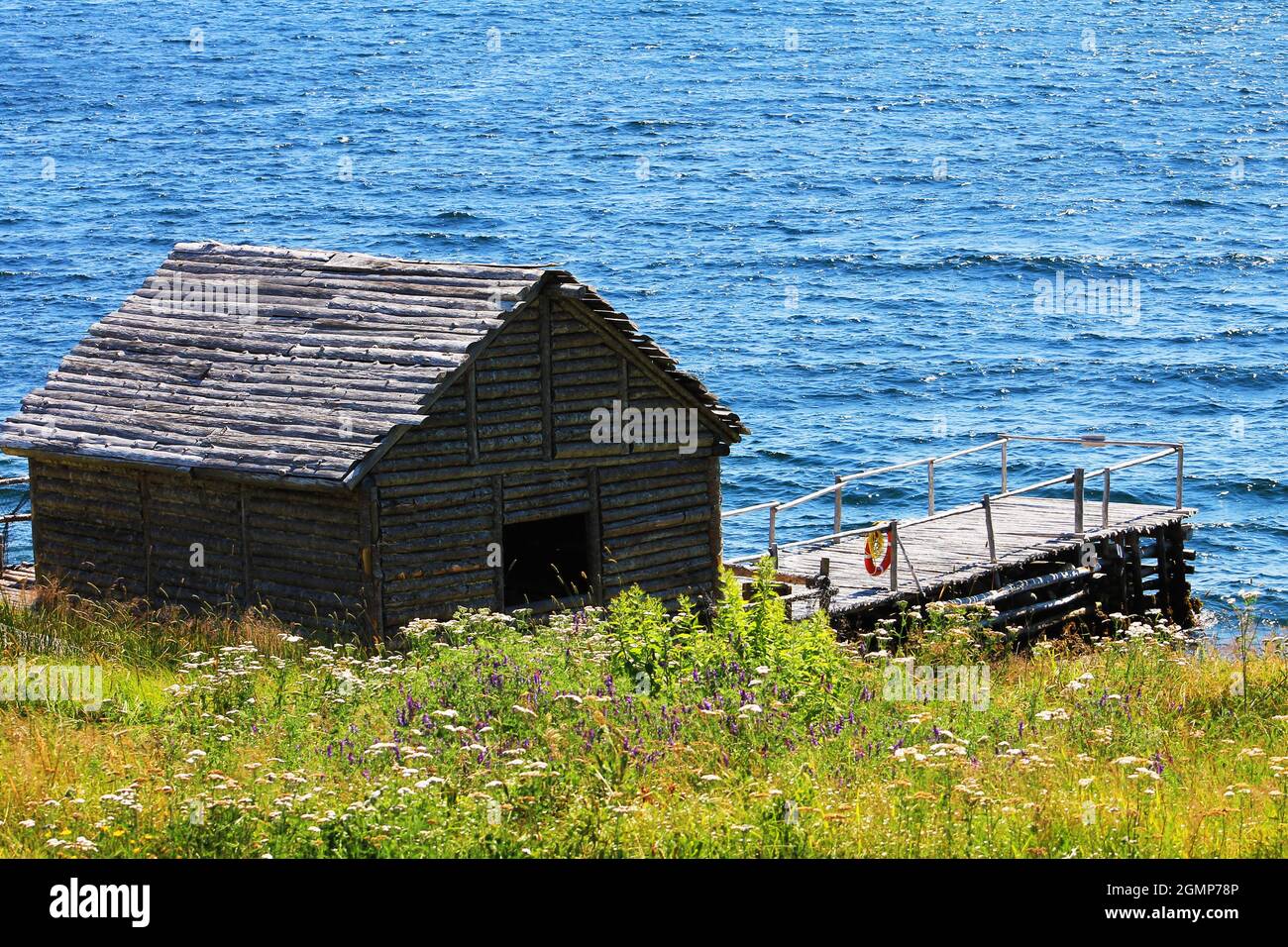 Ein Holzschuppen, eine Bühne und ein Kai am Ufer, Random Passage Site, New Bonaventure, NL. Stockfoto