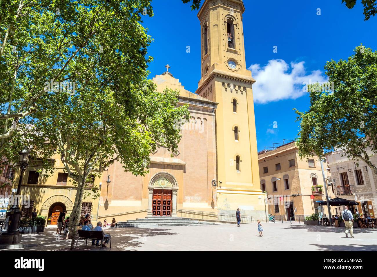 Barcelona, Spanien - 7. Juli 2017: Tagesansicht von Plaça de la Concòrdia und Església de Santa Maria del Remei mit Einheimischen auf Bänken in Barcelona, Spanien. Stockfoto