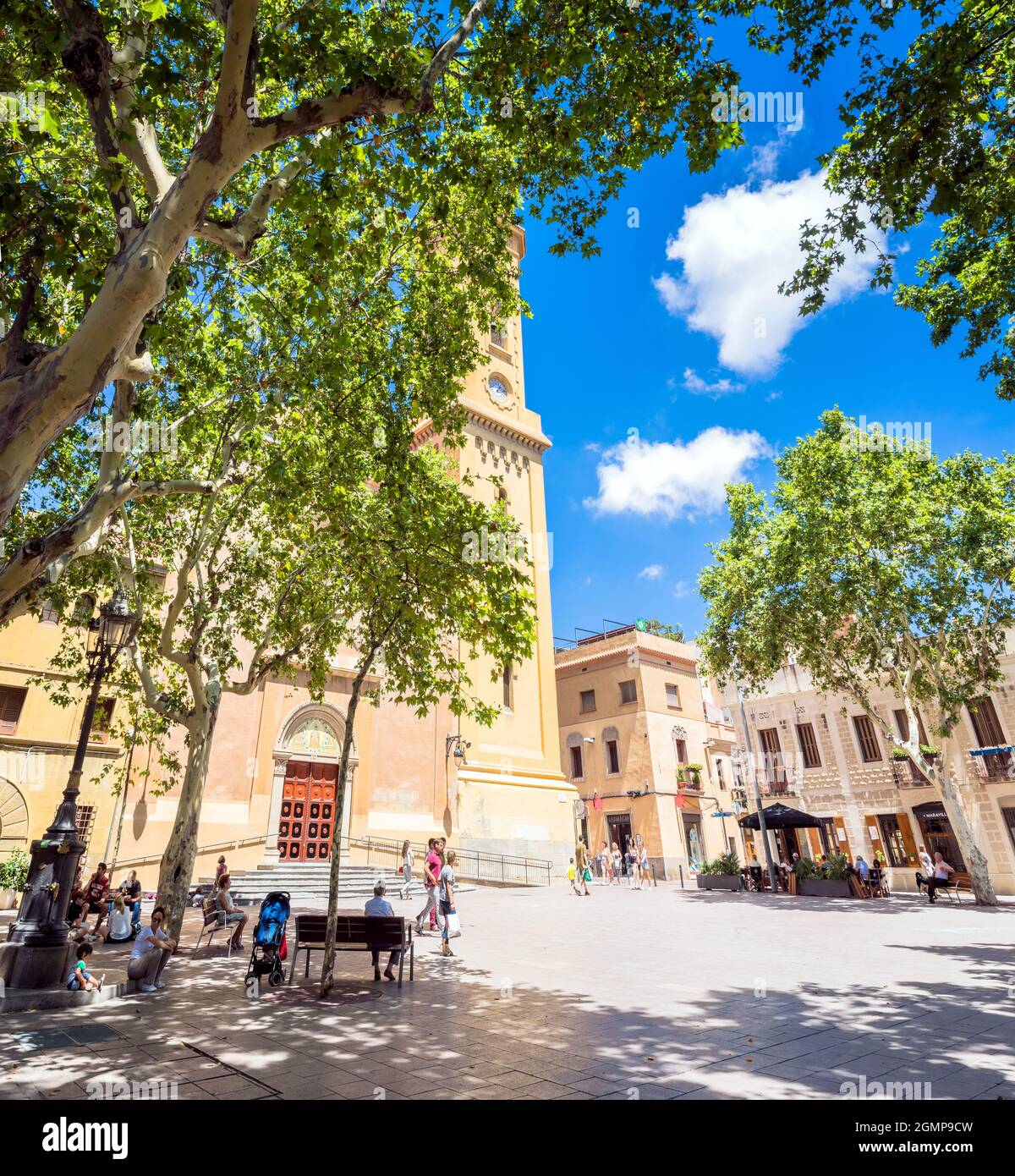 Barcelona, Spanien - 7. Juli 2017: Tagesansicht von Plaça de la Concòrdia und Església de Santa Maria del Remei mit Einheimischen auf Bänken in Barcelona, Spanien. Stockfoto