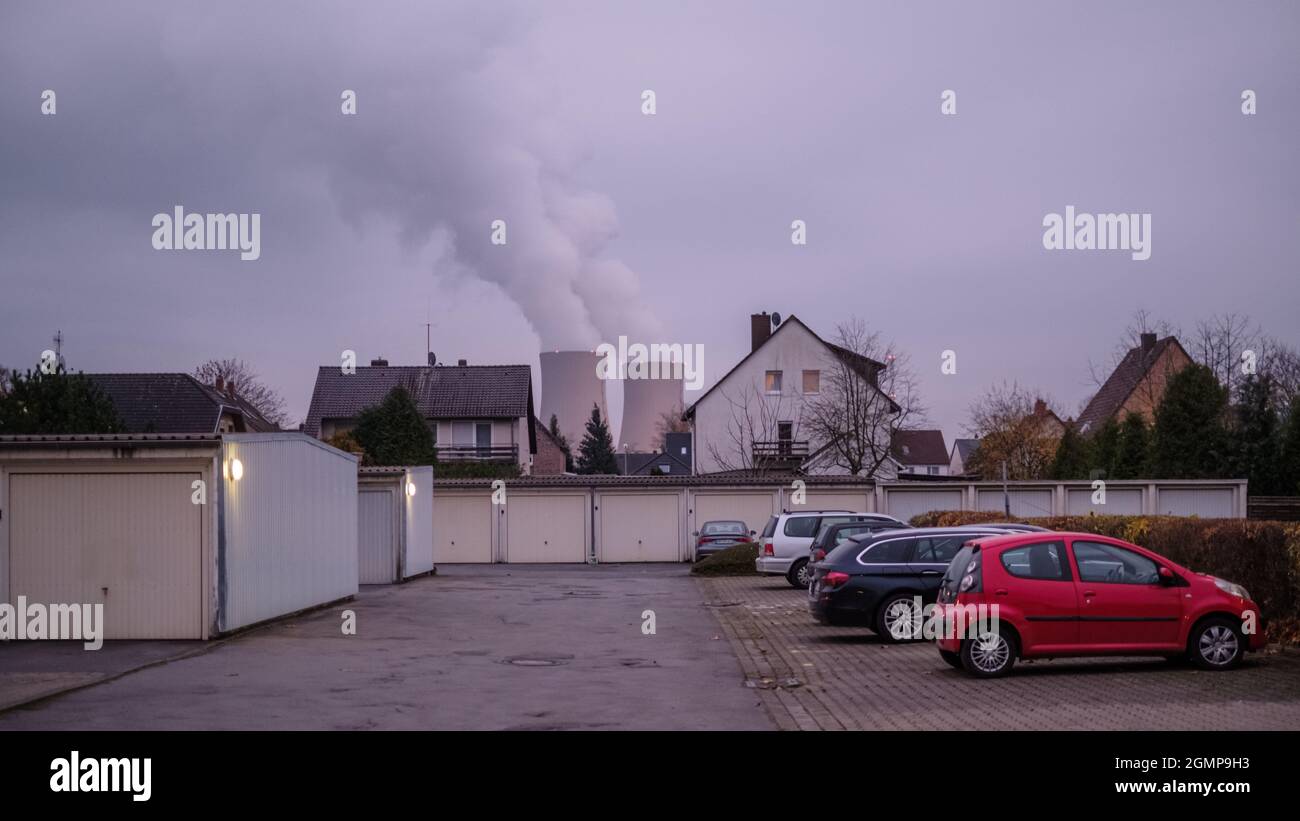 Emmerthal, Deutschland. November 2020. Hinter einer Wohnanlage sind die Kühltürme des Kernkraftwerks Grohnde zu sehen. Das Kernkraftwerk Grohnde liegt rund 40 Kilometer südlich von Hannover und war einst eines der Kraftwerke mit der höchsten Bruttostromerzeugung weltweit. Der Druckwasserreaktor wurde 1985 trotz großer Proteste der Bevölkerung ans Netz angeschlossen und soll Ende 2021 stillgelegt werden. Quelle: Ole Spata/dpa/Alamy Live News Stockfoto