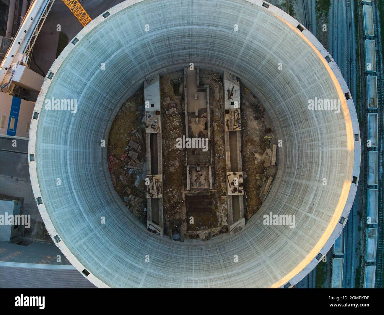 Luftaufnahme der im Bau befindlichen Zementfabrik mit hoher Betonwerksstruktur und Turmdrehkranen im industriellen Produktionsbereich. Fertigung und gl Stockfoto
