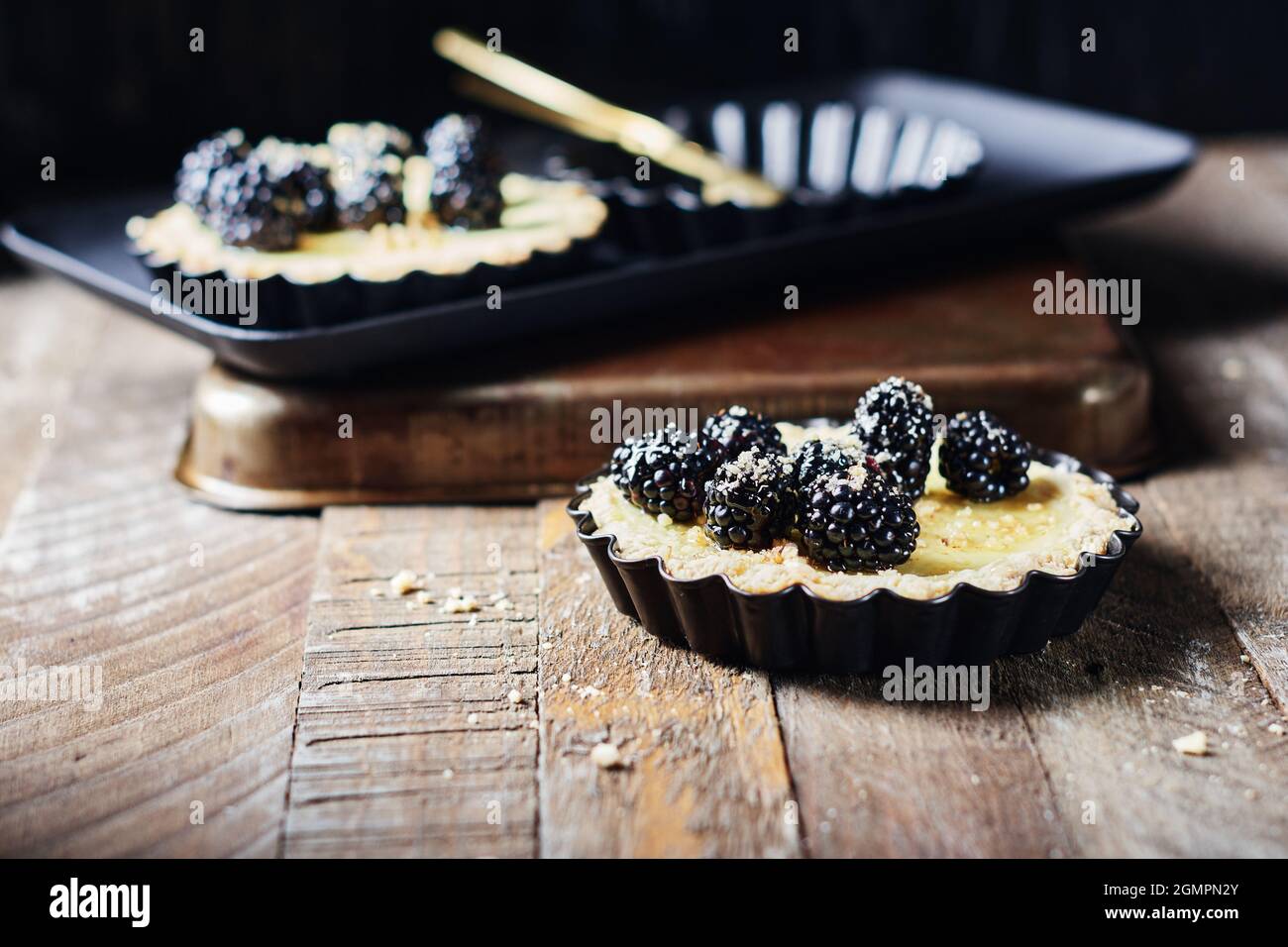 Frisch gebackene Brombeeren- und Vanillepudding-Torten. Stockfoto
