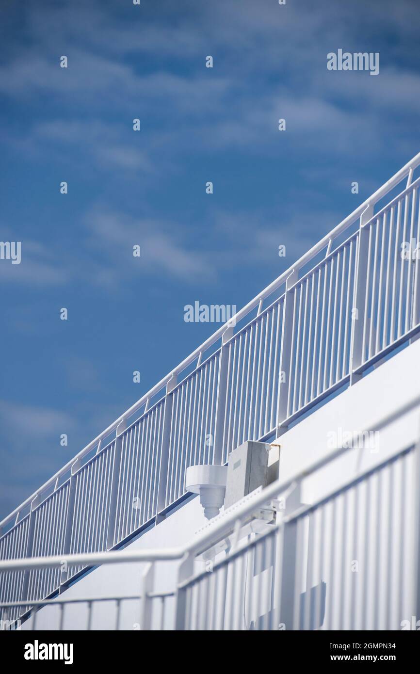 Sicherheitsgeländer auf dem Deck eines Fährschiffes mit blauem Himmel darüber Stockfoto