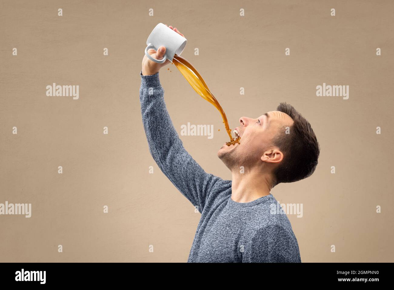 Mann gießt Kaffee direkt in seinen Mund Stockfoto