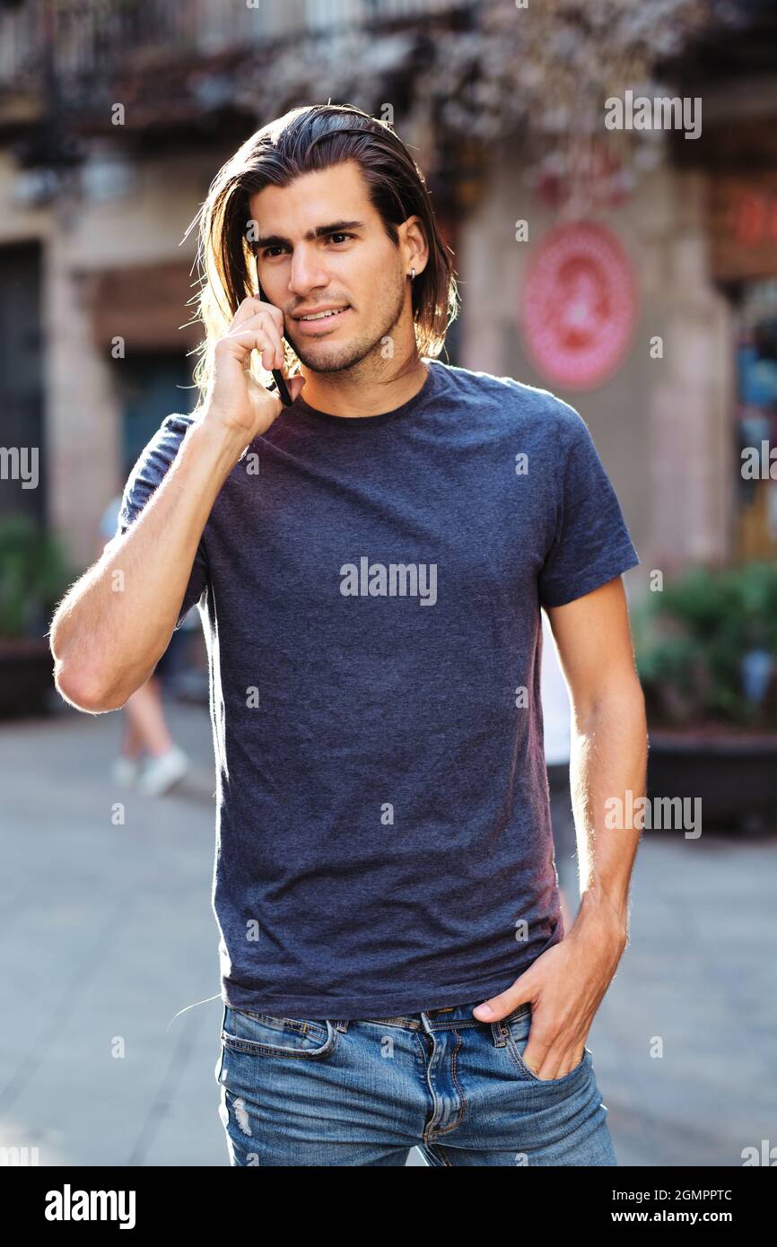 Junges Top-Modell mit lockeren Haaren über ein Smartphone Stockfoto