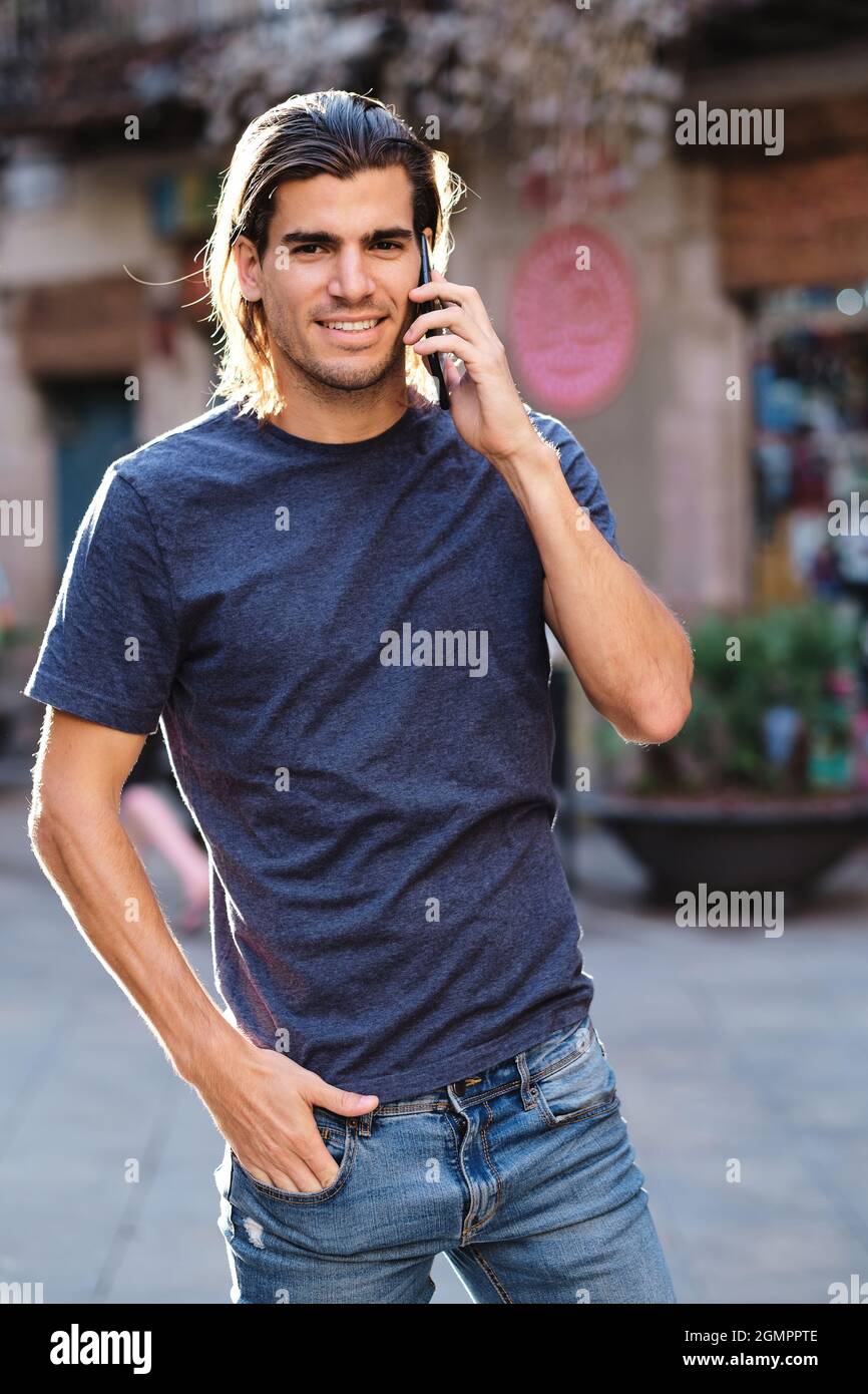 Junges Top-Modell mit lockeren Haaren über ein Smartphone Stockfoto