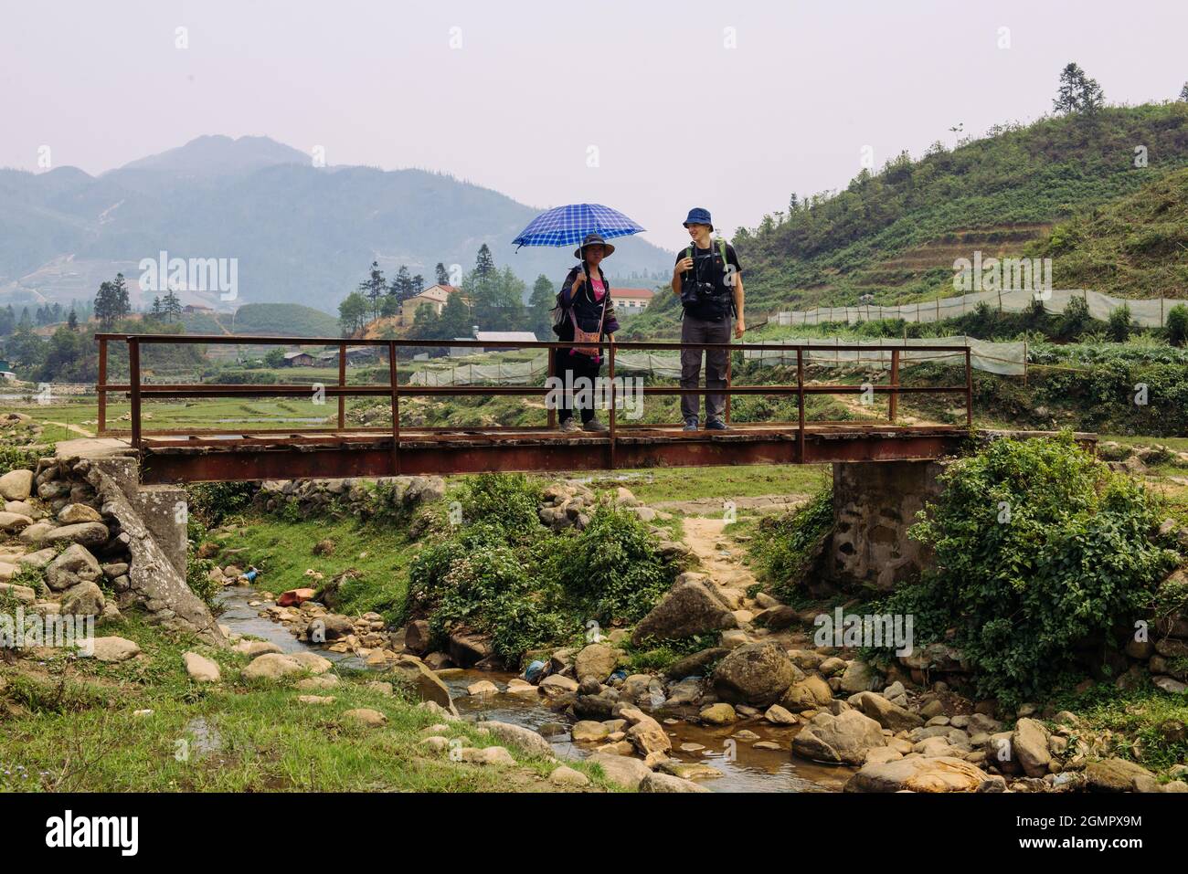 Mann, der im Sommer mit einer Fotokamera unterwegs ist und die grünen Berge fotografiert. Landschaftsfotografie während einer kurzen Pause Stockfoto