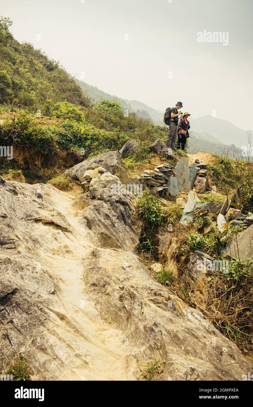 Mann, der im Sommer mit einer Fotokamera unterwegs ist und die grünen Berge fotografiert. Landschaftsfotografie während einer kurzen Pause Stockfoto