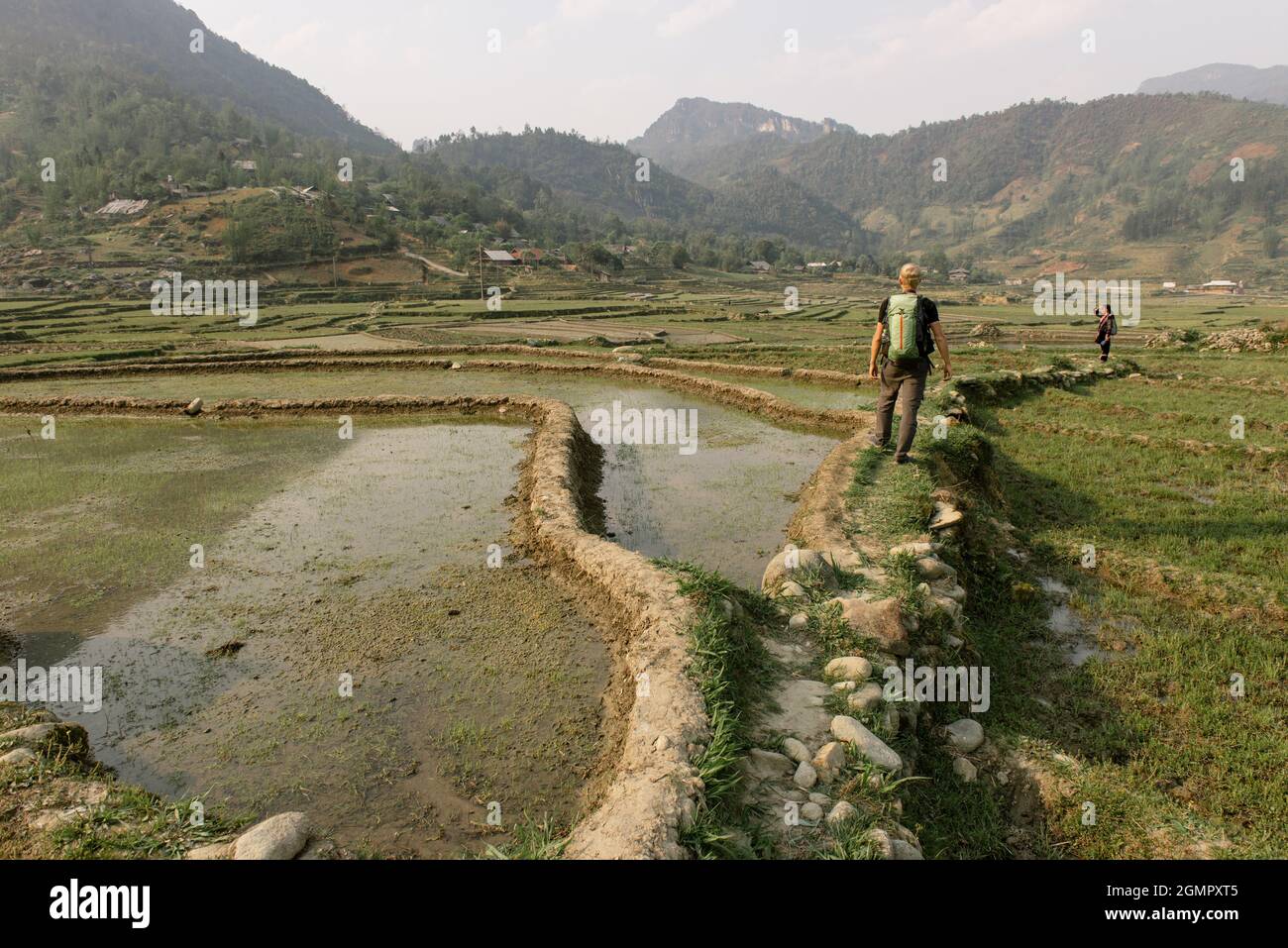 Mann, der im Sommer mit einer Fotokamera unterwegs ist und die grünen Berge fotografiert. Landschaftsfotografie während einer kurzen Pause Stockfoto