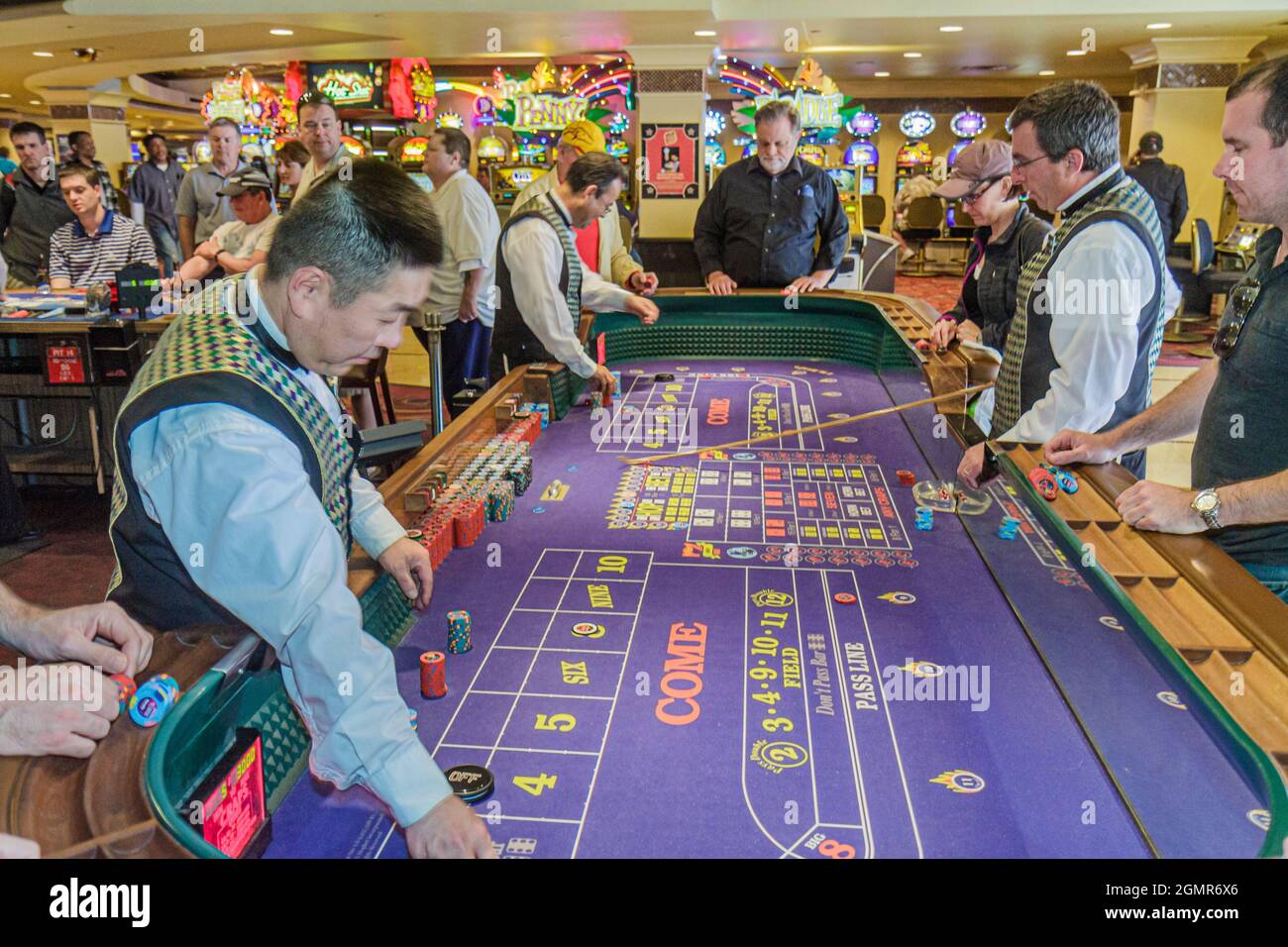 Las Vegas Nevada, der Strip, Harrah's Las Vegas Hotel Casino Craps Tisch, Arbeiter, Asian Mann Boxman Basis Dealer stickman Bettors Spieler spielen Stockfoto