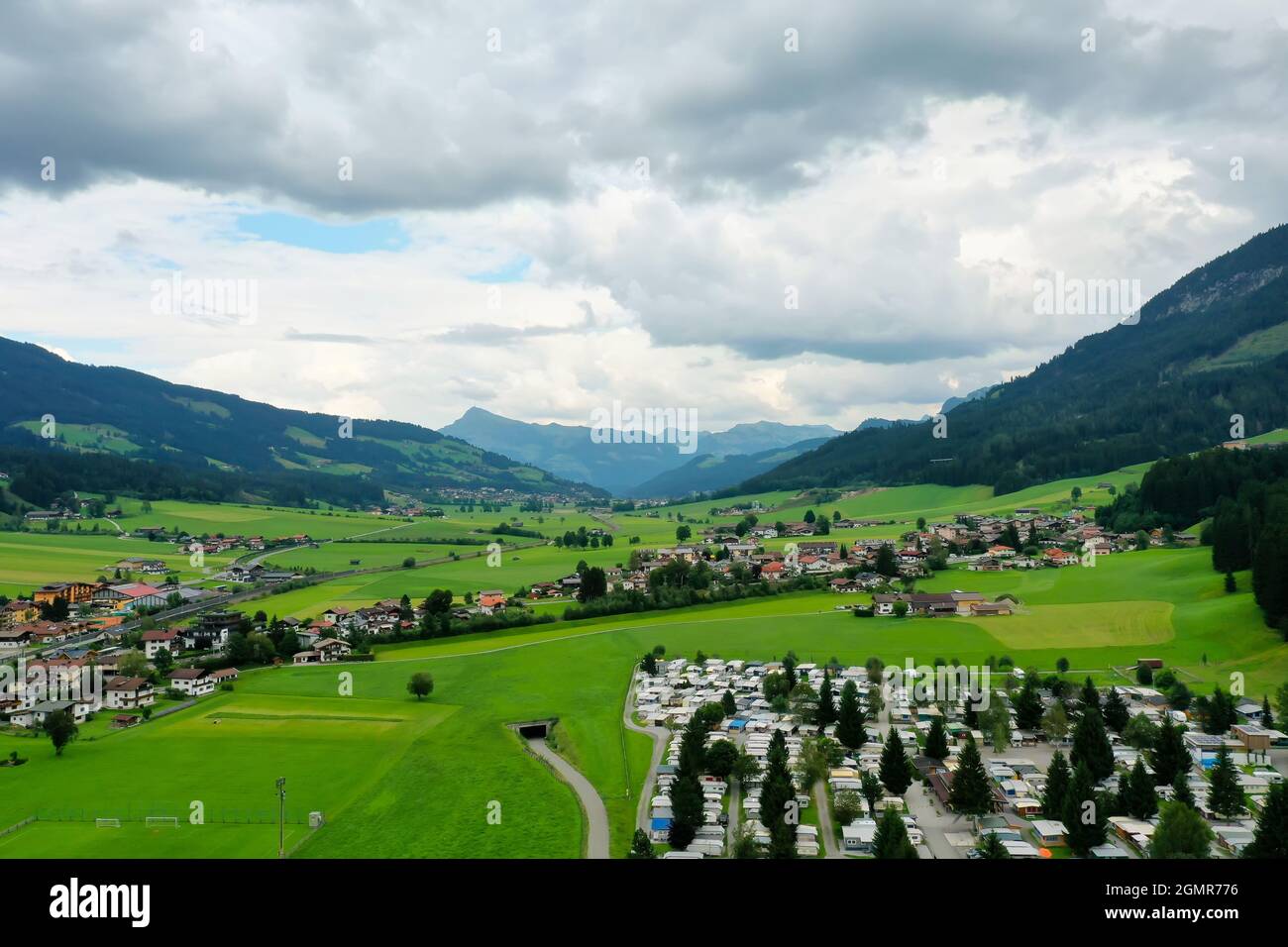 Landschaft einer Stadt umgeben von Hügeln im Grünen in Brixen im Thale, Österreich Stockfoto