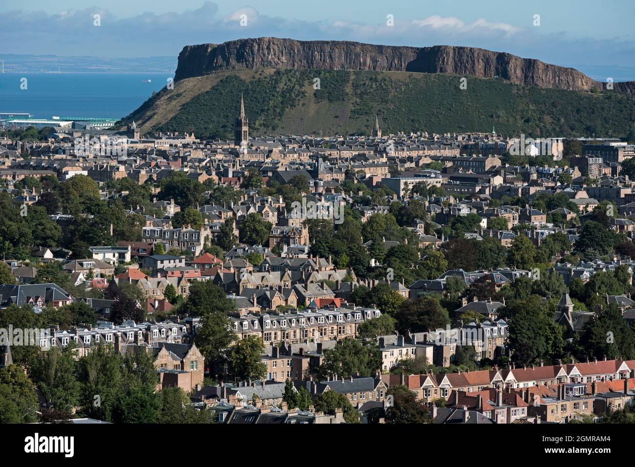 Wohnhäuser in Süd-Edinburgh mit Salisbury Crags im Hintergrund, aufgenommen aus Blackford Hill, Edinburgh, Schottland, Großbritannien. Stockfoto