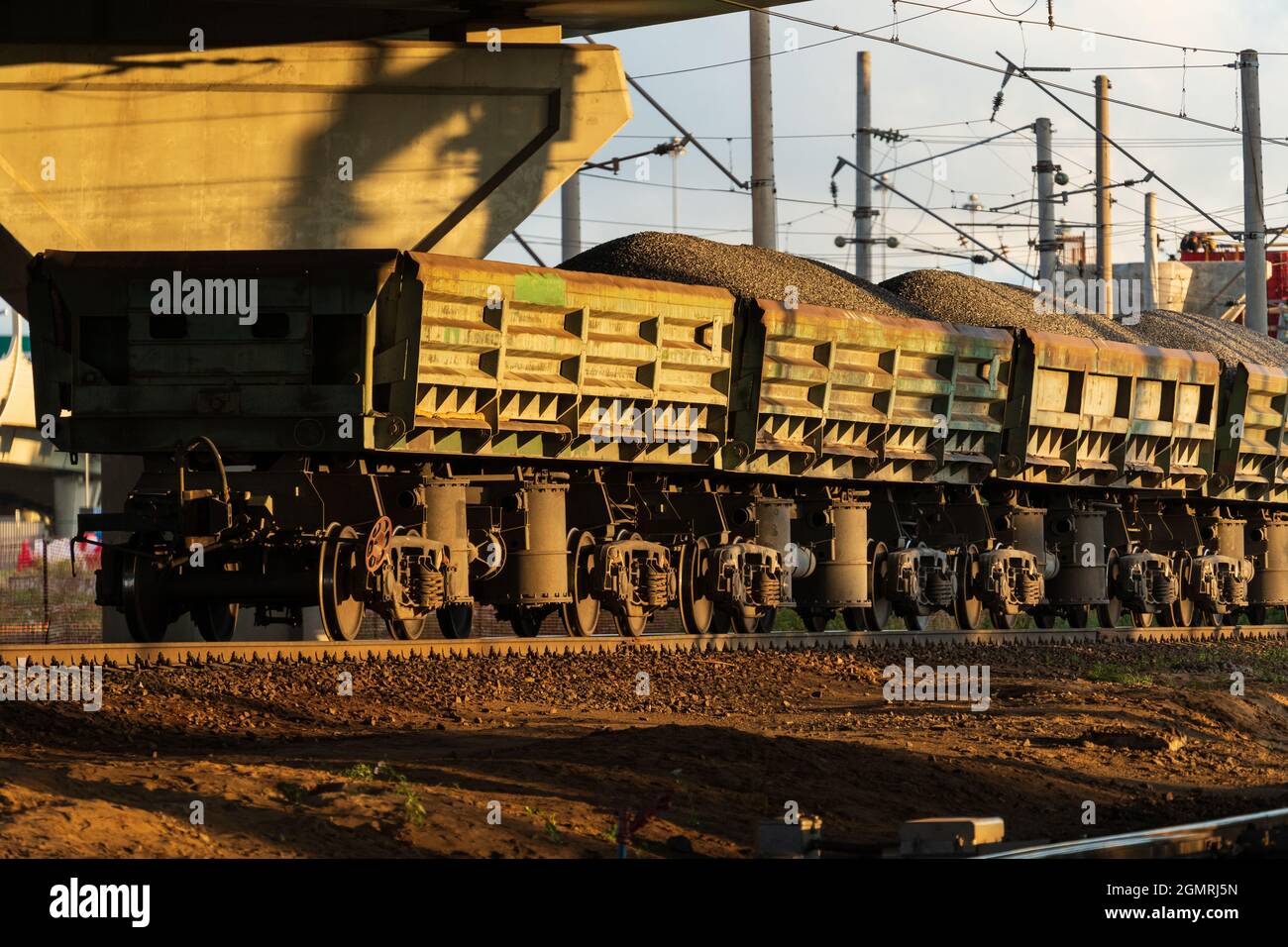 Güterzug auf Schienen. Waggons mit Lieferung von Erz, Schotter, Kohle mit der Eisenbahn Stockfoto