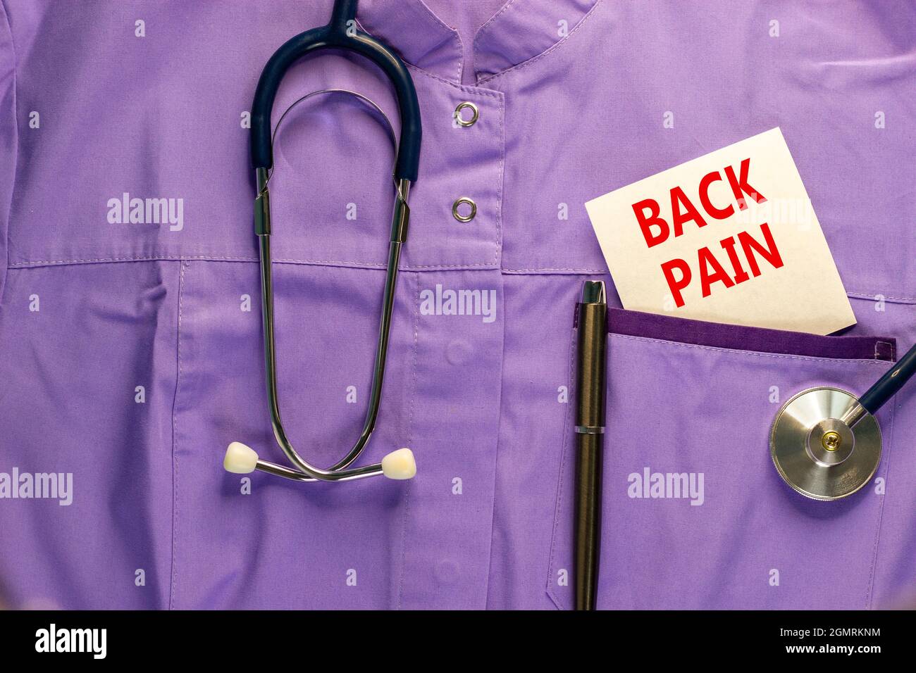 Symbol für Rückenschmerzen. Medizinische Uniform, weiße Karte mit den Worten Rückenschmerzen, metallischer Stift und Stethoskop. Konzept für medizinische und Rückenschmerzen. Stockfoto