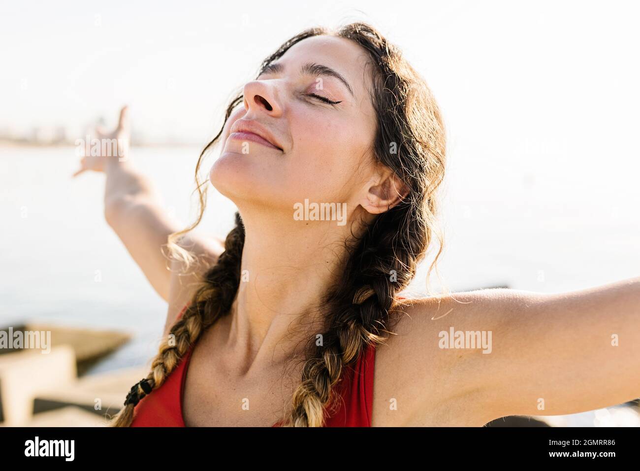 Junge Erwachsene hispanische Frau atmet frische Luft und steht im Sommer am Strand Stockfoto