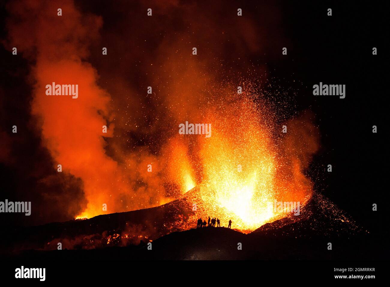 Touristen beobachten einen Vulkanausbruch, Island Stockfoto