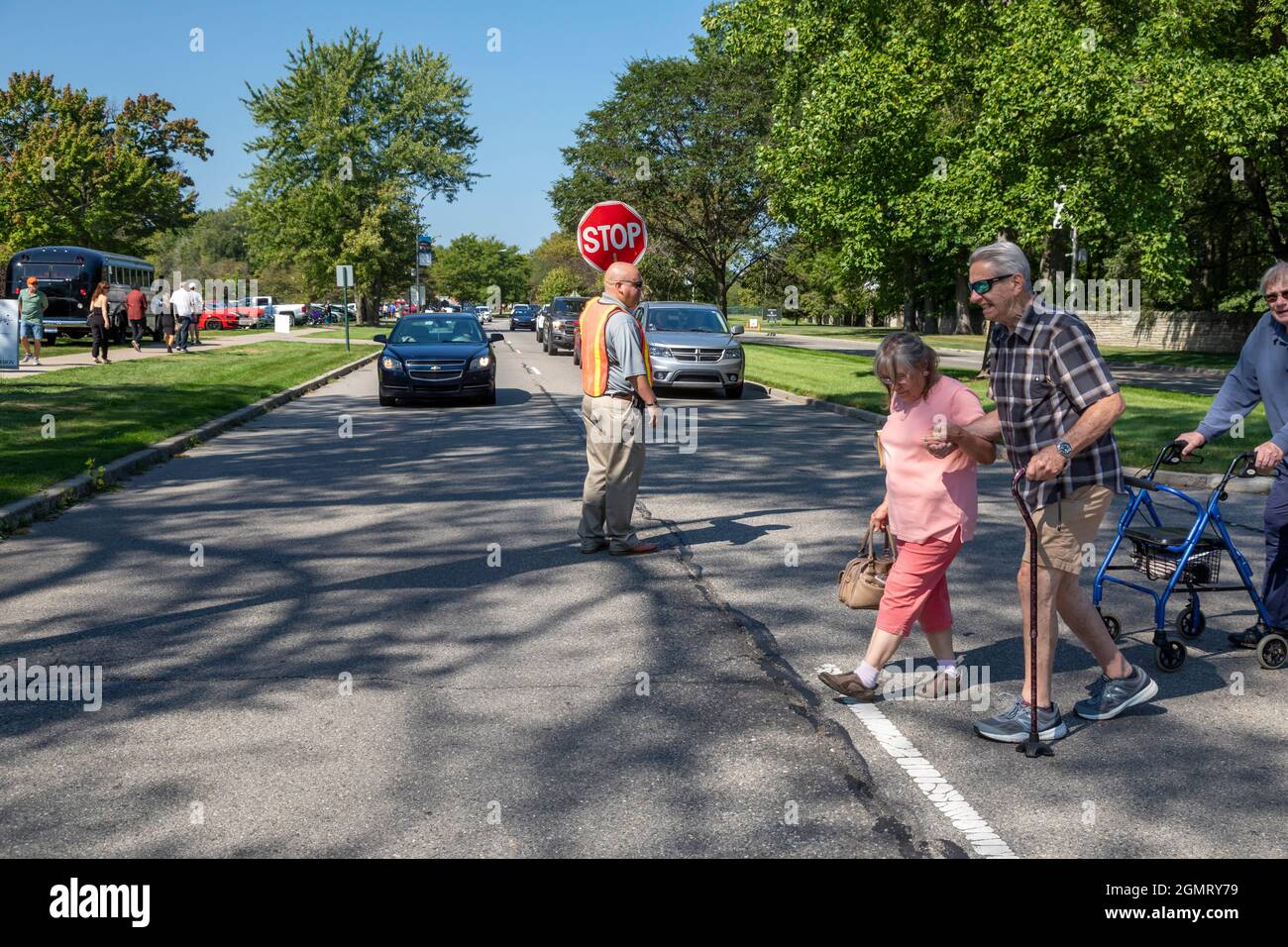 Große Pointe Shores, Michigan - Eine Grenzwache stoppt den Verkehr für Fußgänger, die an der Eyes on Design Auto Show im Edsel & Eleanor Ford Hou teilnehmen Stockfoto