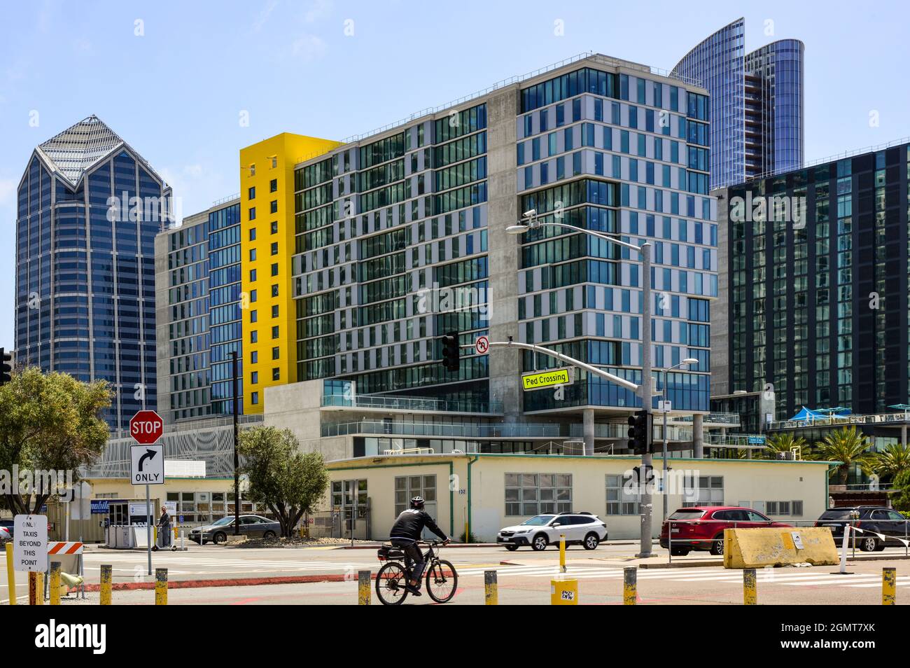 Ein modernes und trendiges Stadtbild mit Hochhauswohnungen und Gebäuden mit einem Fahrradfahrer am Fußgängerübergang in der Nähe der Bay Side am Pacific Highway in San Diego, CA Stockfoto