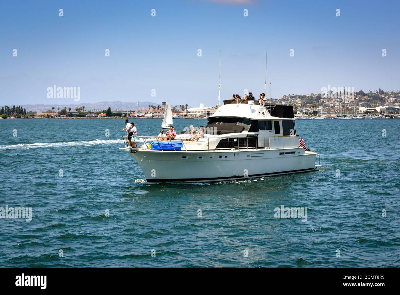 Ein Dutzend Leute feiern an einem wunderschönen Tag in Südkalifornien auf der „Champagne“-Yacht in der Bucht von San Diego Stockfoto