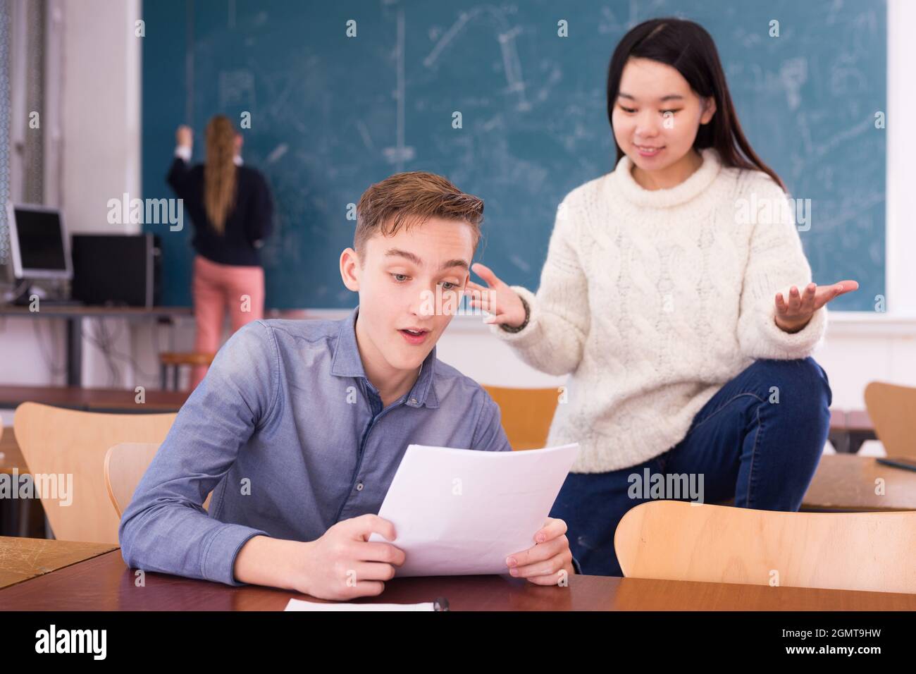 Erfreut Teenager und chinesisches Mädchen Schulkamerad Lesung Benachrichtigung Stockfoto