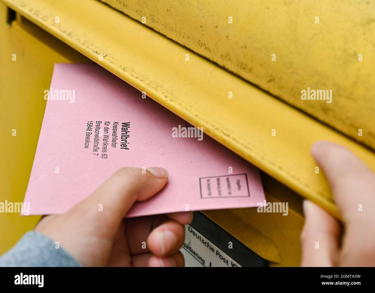 Sieversdorf, Deutschland. September 2021. Eine Person legt ihre postalischen Stimmdokumente in eine Mailbox der Deutschen Post. Der Umschlag enthält den aktuellen Stimmzettel und die Stimmdokumente als Briefwahl für die Bundestagswahl am Sonntag, 26. September 2021. Quelle: Patrick Pleul/dpa-Zentralbild/ZB/dpa/Alamy Live News Stockfoto