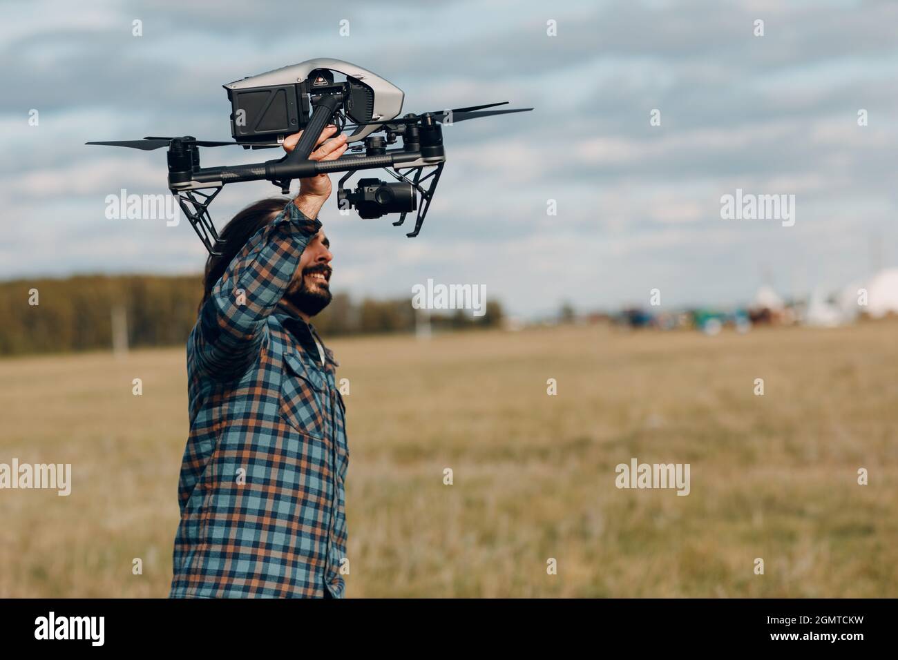 Man Pilot hält DJI Inspire 2 Quadcopter Drohne in den Händen auf dem Außenfeld Stockfoto