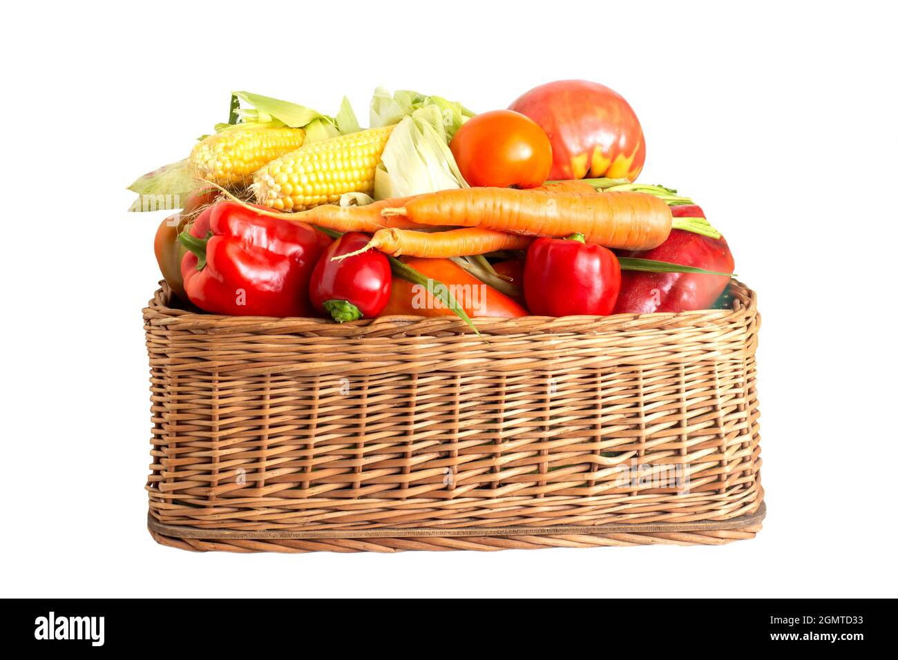Korb mit Sommer- und Herbstgemüse auf weißem Hintergrund. Paprika, Karotten und Maiskolben mit Tomaten, isolieren, gesundes Essen Stockfoto