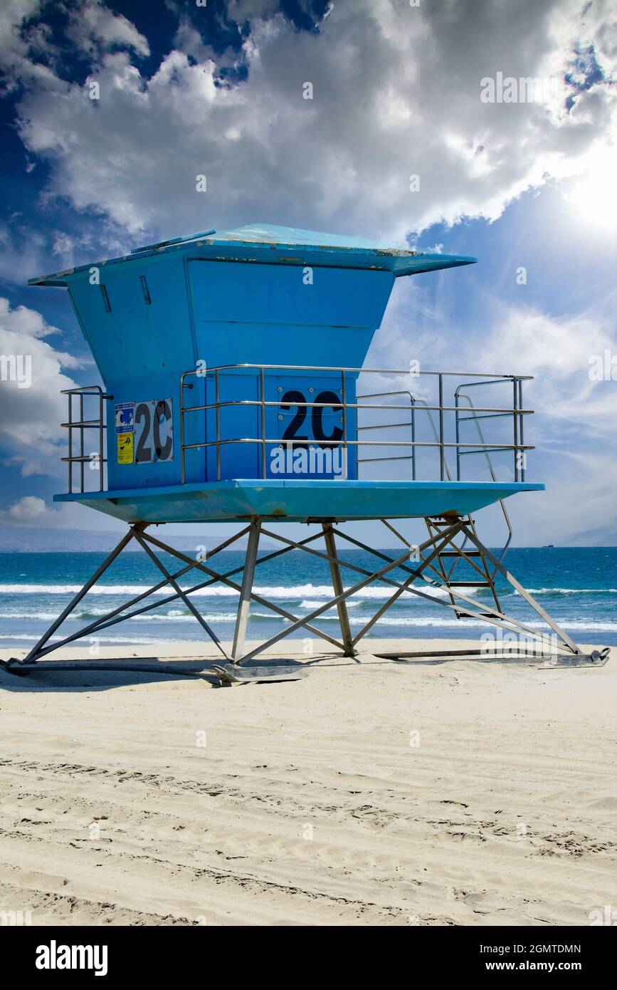 Der legendäre südkalifornische Rettungsschwimmer-Turm steht in Blau am weißen Sandstrand Coronado Beach mit dramatischen Wolken in der Nähe von San Diego, CA, USA Stockfoto