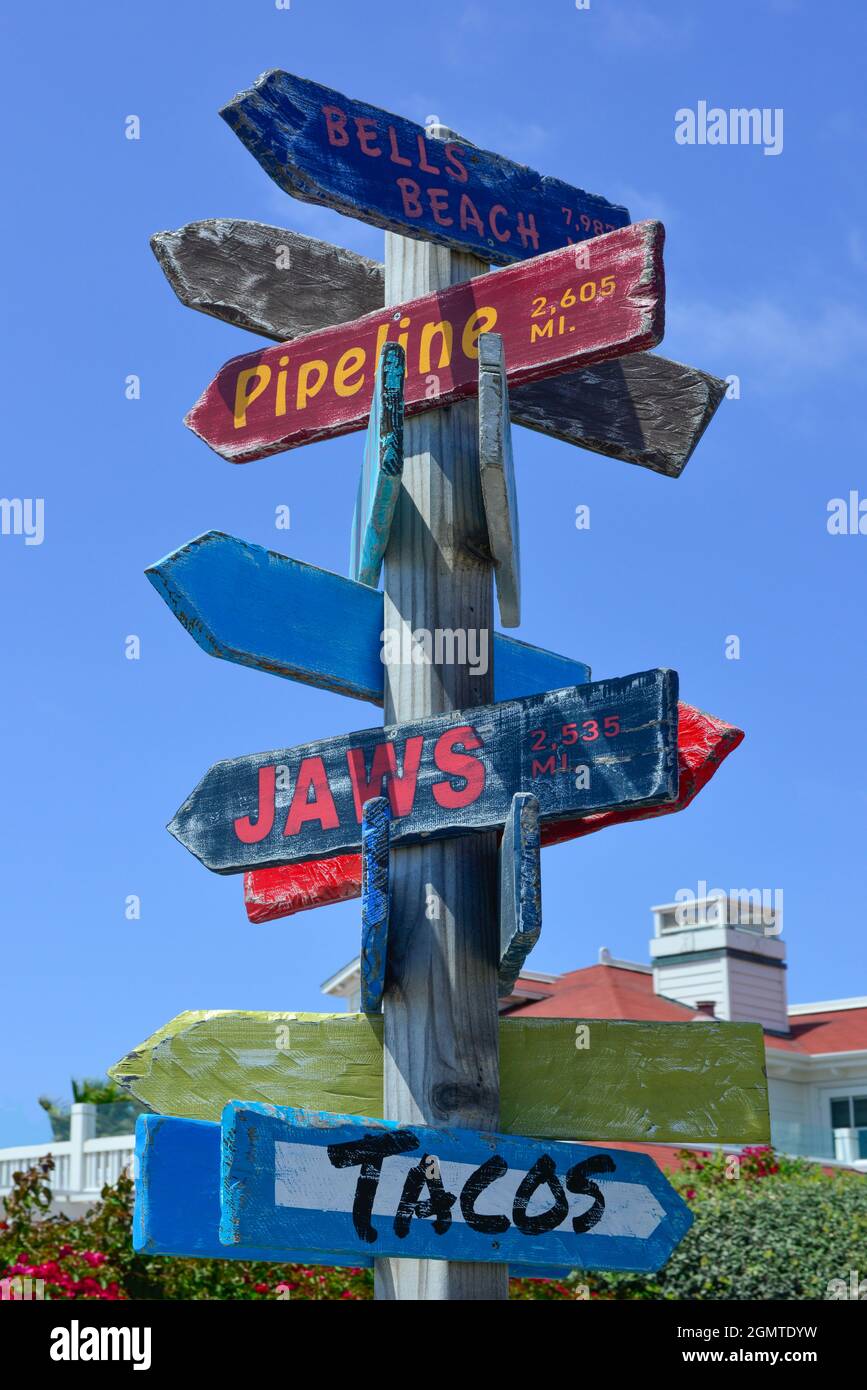 Ein farbenfroher hölzerner Wegweiser mit Wegweiser zum Beach Arrow mit Kilometerstand im kultigen Strandkultur-Stil in Südkalifornien am Coronado Beach, S Stockfoto