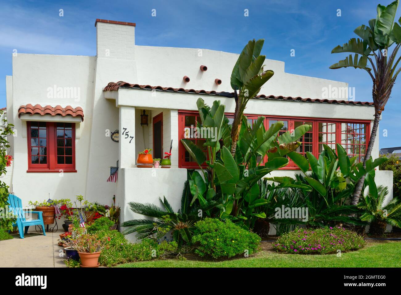 Ein altes, cremeweißes Haus im kalifornischen Bungalowstil mit roten Zierleisten und wunderschöner Küstenvegetation auf Coronado Island, San Diego, CA Stockfoto