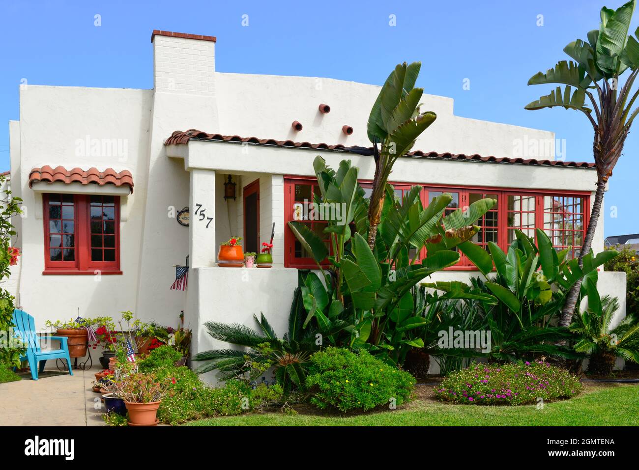 Ein altes, cremeweißes Haus im kalifornischen Bungalowstil mit roten Zierleisten und wunderschöner Küstenvegetation auf Coronado Island, San Diego, CA Stockfoto