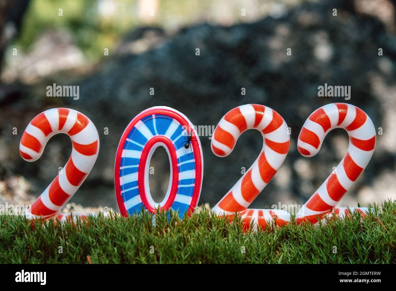 Kreative Neujahr und Weihnachtskarte.Hell, bunt, lustig gestreiften Zahlen 2022 im Wald, auf Moos.Tourism, Abenteuer und Reisekonzept. Nahaufnahme. Stockfoto