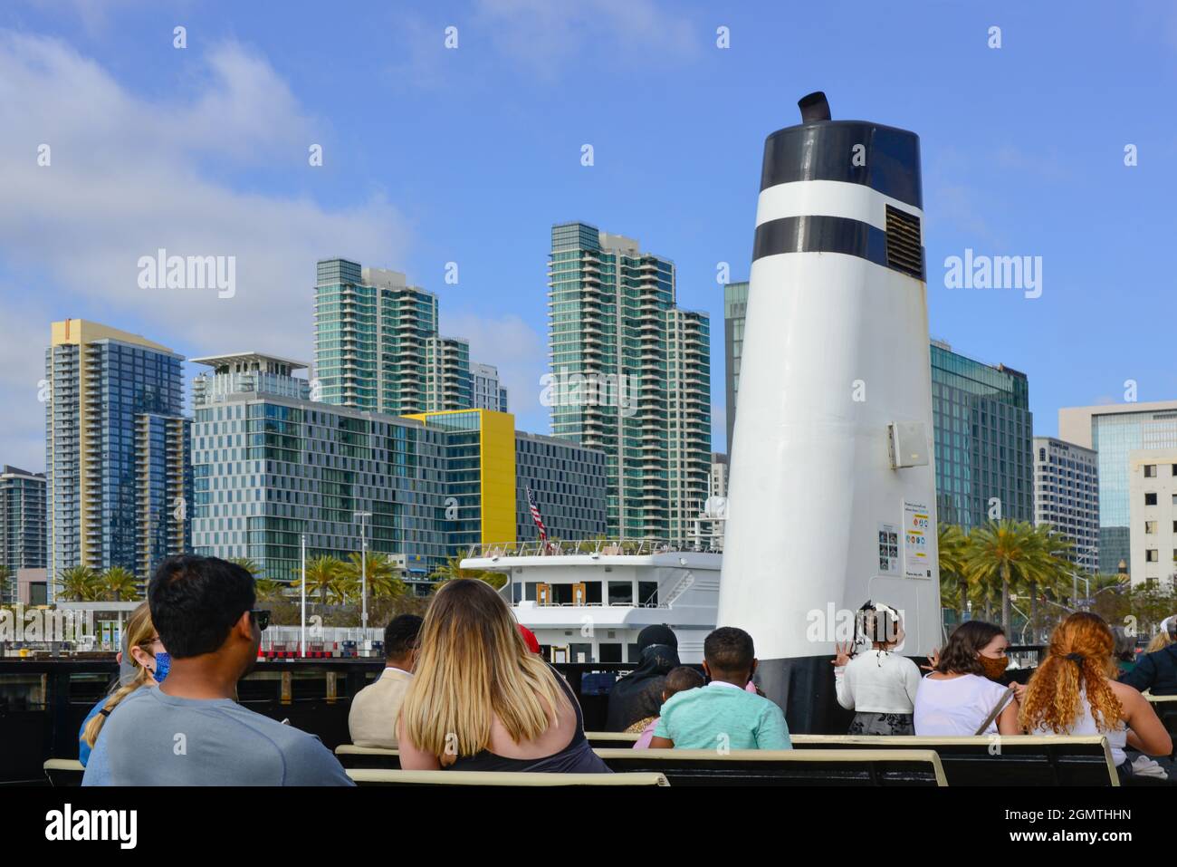 Rückansicht der Passagiere auf dem Open-Air-Deck des Cabrillo, der San Diego Fähre nach Coronado, Andocken mit einer modernen Skyline-Kulisse, San Diego, CA Stockfoto