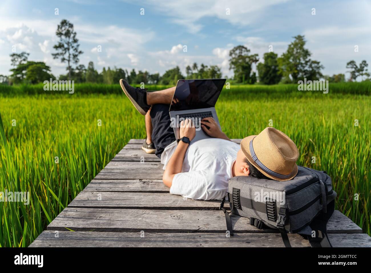 Asain jungen Mann arbeiten, mit Laptop-Computer in der Natur. Freiberufliche Arbeit, Urlaub, Fernarbeit, soziale Distanzierung, E-Learning, Anschluss, creativ Stockfoto