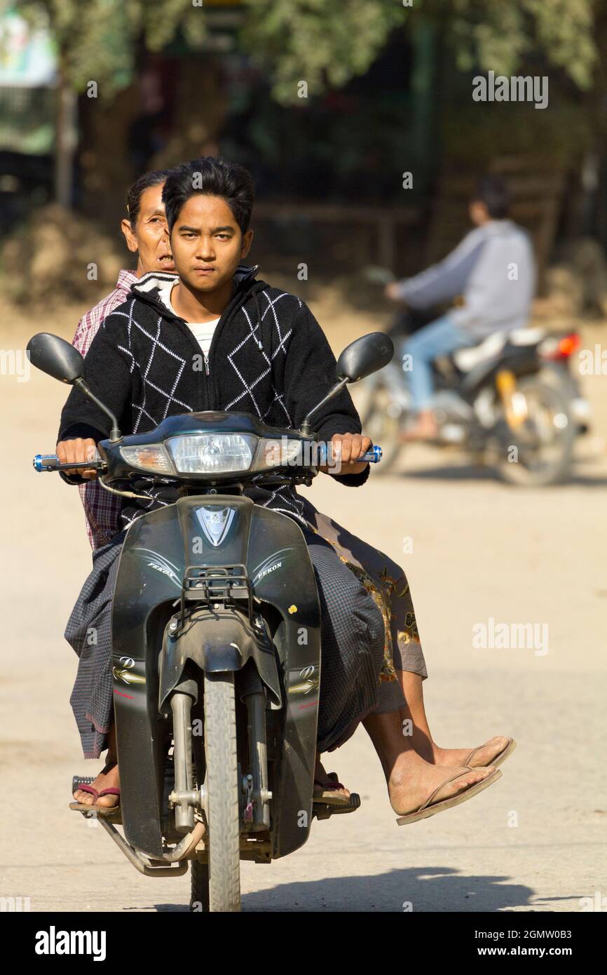 Bagan, Myanmar - 29. Januar 2013 Alltagsszene in einer belebten Straße in Myanmar. Mann und Oma auf einem Moped. Keine Sorge. Was könnte schief gehen? Stockfoto