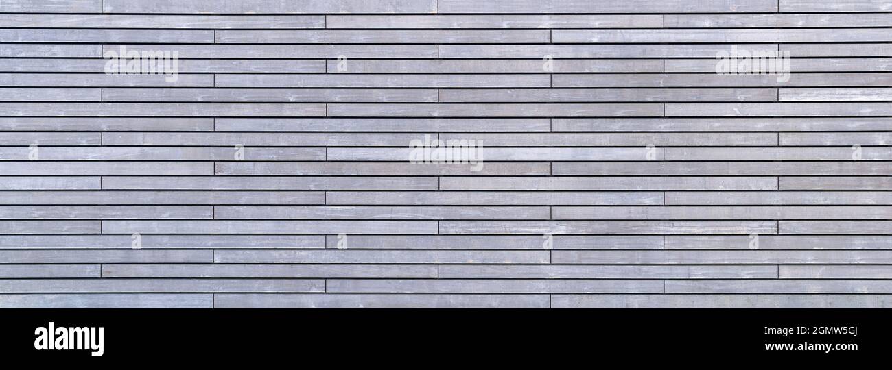 Graue Holzvertäfelung aus schmalen horizontalen Brettern an einer Fassade Stockfoto