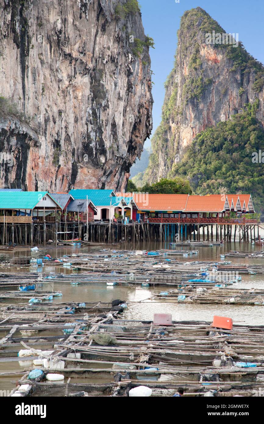 Ein Sea Gypsy Village auf Stelzen in der Phang Na Bay der Andamanensee, Thailand. Eine Fischfarm liegt direkt vor der Küste. Hinter dem Dorf und in der Ferne kann Stockfoto