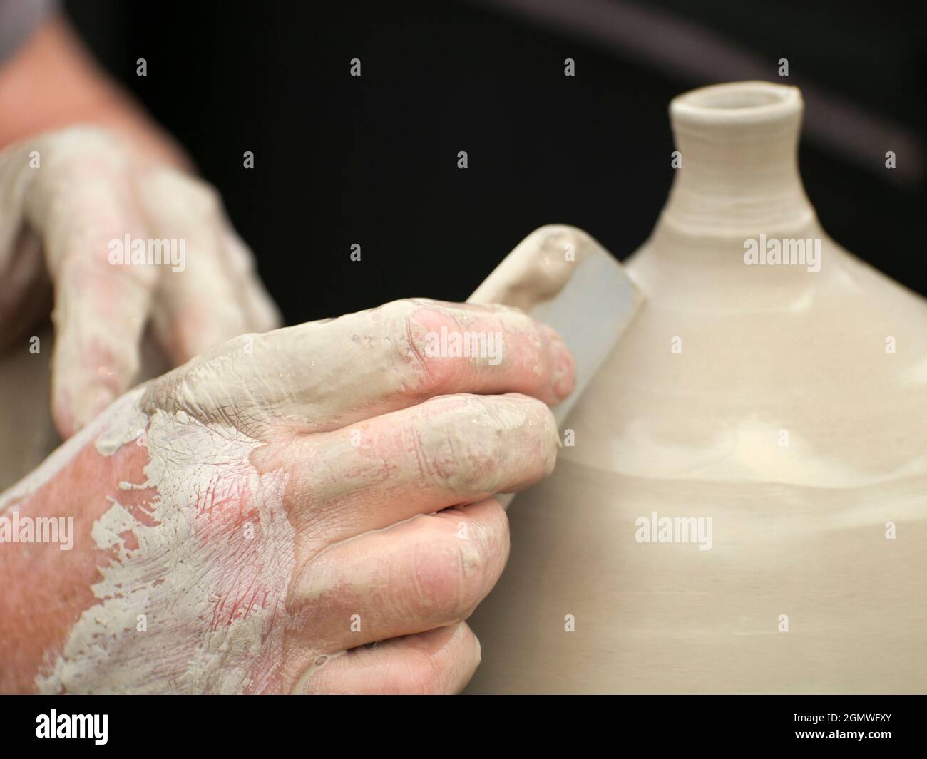 Wheatley, Oxfordshire, Großbritannien - Juli 2011; The Art of Creation. Oder ist es die Schaffung von Kunst?: Sie wählen. Ein Töpfer wirft und beendet eine Vase bei einem FI Stockfoto