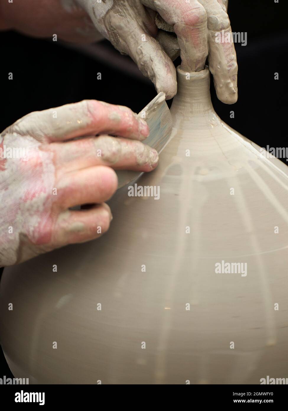 Wheatley, Oxfordshire, Großbritannien - Juli 2011; The Art of Creation. Oder ist es die Schaffung von Kunst?: Sie wählen. Ein Töpfer wirft und beendet eine Vase bei einem FI Stockfoto