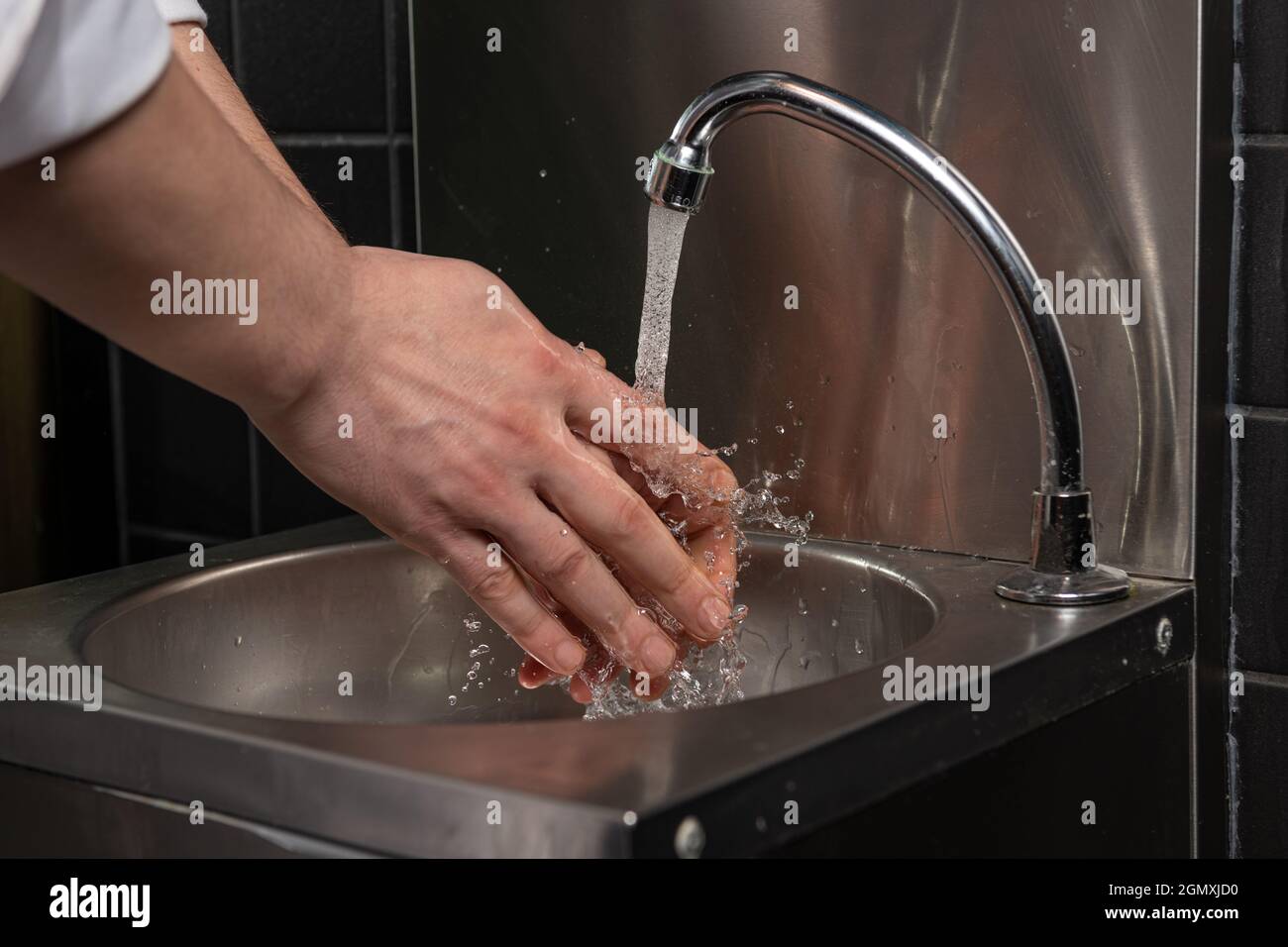 Nahaufnahme von Männern, die sich mit Wasser die Hände waschen. Stockfoto Nahaufnahme von Männern, die sich mit Wasser die Hände waschen. Stockfoto