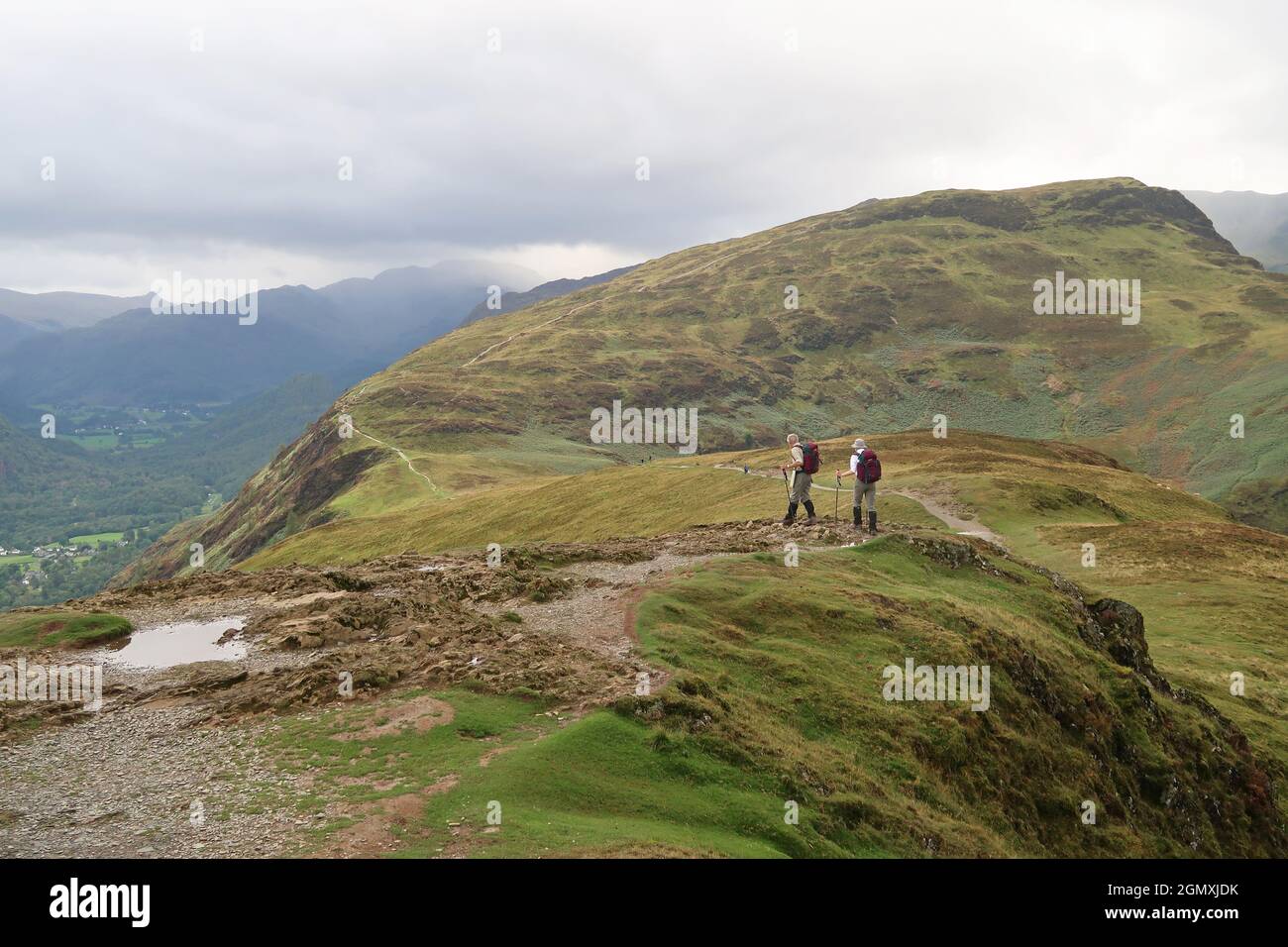 Ein älteres Paar geht den Ridge Path entlang Cat Bells, Lake District, Großbritannien. Erfahrene Wanderer mit passender Kleidung und Ausrüstung. Stockfoto